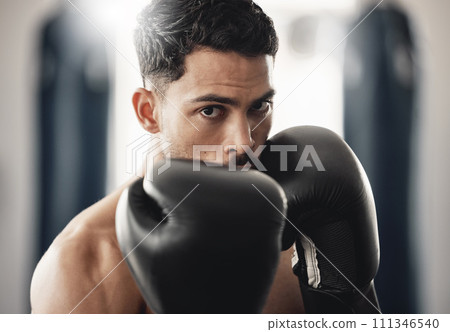 Fitness portrait of man boxer ready to punch during mma, boxing or fighting workout. Athlete boxing in the gym during training, exercise or practice for a fight, match or competition at a sport club Fitness portrait of man boxer ready to punch during mma, boxing or fighting workout. Athlete boxing in the gym during training, exercise or practice for a fight, match or competition at a sport club 111346540
