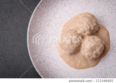 Delicious meatballs from minced chicken or turkey with sour cream sauce Delicious meatballs from minced chicken or turkey with sour cream sauce 111346885