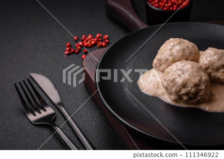 Delicious meatballs from minced chicken or turkey with sour cream sauce 111346922