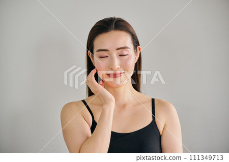 A woman in her 30s taking care of her skin by massaging her face 111349713