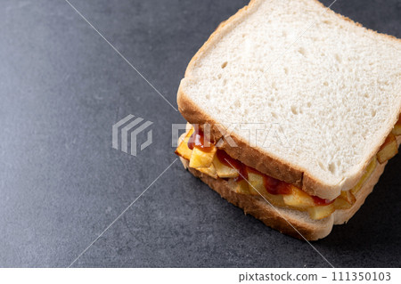 Sliced white bread on black slate background 111350103