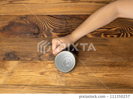 Hand Holds Cup, Empty Cup in Hands, Coffee Mug, Teacup Mockup, Cup in Arms on Wooden Table 111350257