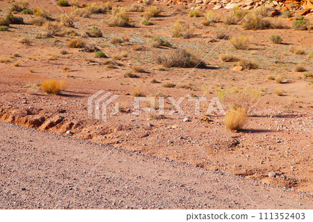Sandy road of red sand in the mountains. Sandy road of red sand in the mountains. 111352403