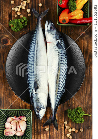 Raw mackerel fish on wooden background. 111352692