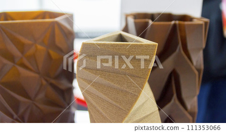 Art object vase printed on 3D printer from melted brown plastic with addition waste coffee. Model made of plastic with spent coffee by 3d printer. Additive progressive technology 3D printing recycling 111353066