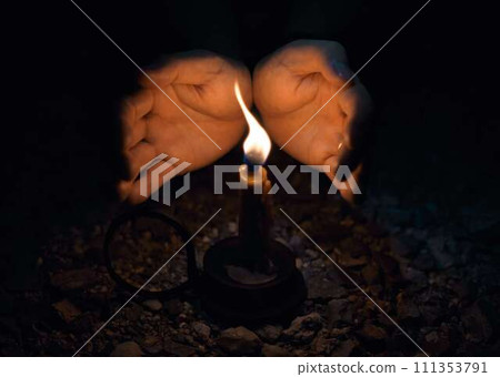 the hand of a person lighting a fire the hand of a person lighting a fire 111353791