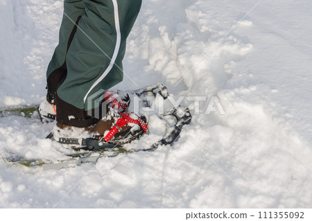 Detail, close view  to snowshoes,  side view, man walks in the snow. 111355092