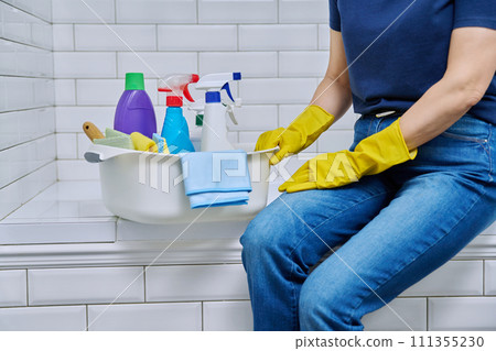 House cleaning concept, basin with cleaning products and hands in gloves House cleaning concept, basin with cleaning products and hands in gloves 111355230