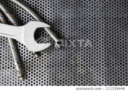 Plumbing parts, accessories and tools on a gray metal background with a dedicated copy space. Plumbing parts, accessories and tools on a gray metal background with a dedicated copy space. 111356446