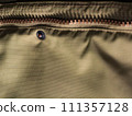Zipper on beige workwear protective clothing in close-up. 111357128