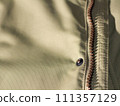 Zipper on beige workwear protective clothing in close-up. 111357129