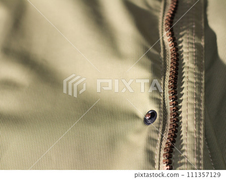 Zipper on beige workwear protective clothing in close-up. 111357129