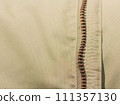 Zipper on beige workwear protective clothing in close-up. 111357130