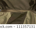 Zipper on beige workwear protective clothing in close-up. 111357131