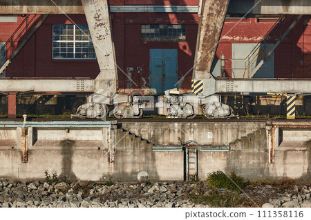 Old quay with rusty industrial cranes, warehouses Old quay with rusty industrial cranes, warehouses 111358116