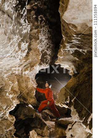 A portrait of a young female caver exploring the cave 111358894