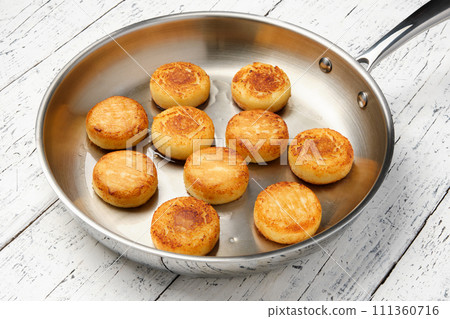 Cottage cheese pancakes. Syrniki in a frying pan. Cheesecakes. Cottage cheese pancakes. Syrniki in a frying pan. Cheesecakes. 111360716