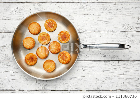 Cottage cheese pancakes. Syrniki in a frying pan. Cheesecakes, top view, flat lay. 111360730