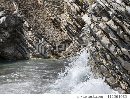 Waves splashing at rocks at the beach Waves splashing at rocks at the beach 111361083