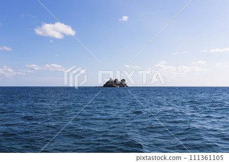 View of  island called Sveta Nedelja (St. Sunday) near Petrovac, Montenegro and blue sky with white fluffy clouds in background 111361105