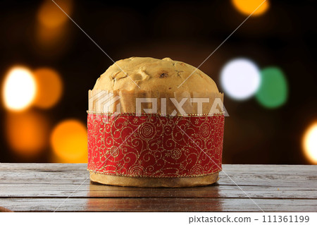 panettone, decorative food, on wooden table, blurred lights in the background panettone, decorative food, on wooden table, blurred lights in the background 111361199