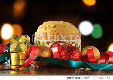 panettone, decorative food, on wooden table, blurred lights in the background panettone, decorative food, on wooden table, blurred lights in the background 111361235