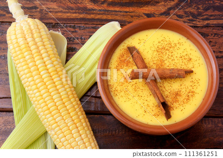 Curau, cream of corn sweet and dessert typical of the Brazilian cuisine, with cinnamon placed in ceramic bowl on wooden table. Top view 111361251