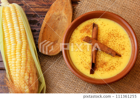 Curau, cream of corn sweet and dessert typical of the Brazilian cuisine, with cinnamon placed in ceramic bowl on wooden table. Top view 111361255