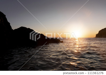 Sunset with yellow sun at the horizon at sea 111361276