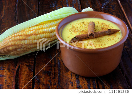 Curau, cream of corn sweet and dessert typical of the Brazilian cuisine, with cinnamon placed in ceramic bowl on wooden table. Copy space 111361286