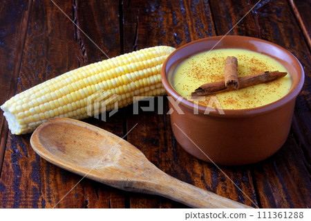 Curau, cream of corn sweet and dessert typical of the Brazilian cuisine, with cinnamon placed in ceramic bowl on wooden table. Copy space 111361288