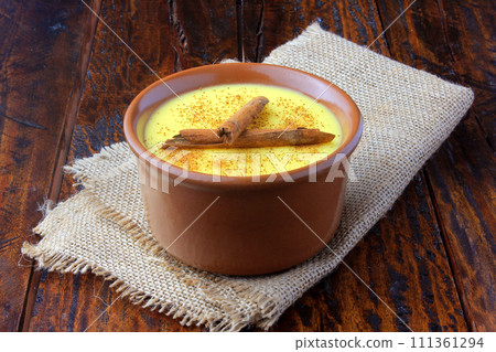 Curau, cream of corn sweet and dessert typical of the Brazilian cuisine, with cinnamon placed in ceramic bowl on wooden table. Copy space 111361294