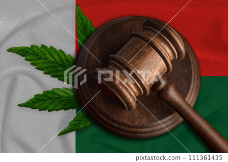 Justice wooden gavel with cannabis leaf on the Flag of Madagascar. Illegal growth of cannabis plant and drugs spreading 111361435