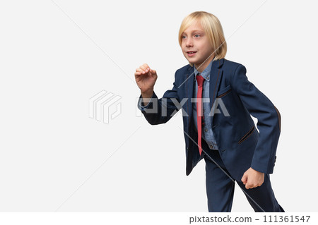 A boy in a business suit runs away. Isolated on white background. A boy in a business suit runs away. Isolated on white background. 111361547