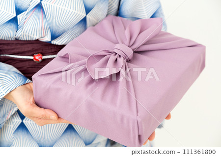 一位穿著浴衣的中年婦女拿著包袱皮作為夏季禮物 111361800