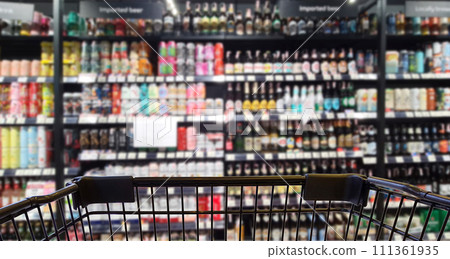Abstract blurred image of alcohol store with trolley in department store. (Selective focused at shopping cart) Abstract blurred image of alcohol store with trolley in department store. (Selective focused at shopping cart) 111361935