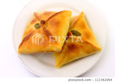 Chicken esfiha of arabic origin traditionally adapted for brazilian cuisine on plate on white background Chicken esfiha of arabic origin traditionally adapted for brazilian cuisine on plate on white background 111362064