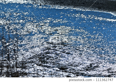 The waterfront of the main stream of Arakawa, sparkling reflections, near Hanazono Mizube Park 111362747