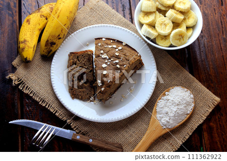 Healthy homemade banana cake made with oatmeal on rustic wooden table. sugar-free, milk-free, gluten-free Healthy homemade banana cake made with oatmeal on rustic wooden table. sugar-free, milk-free, gluten-free 111362922