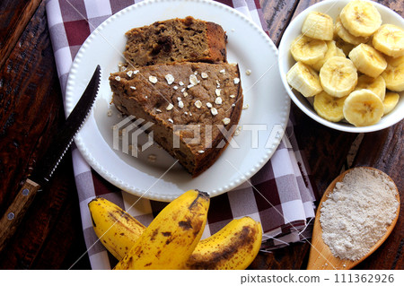 Healthy homemade banana cake made with oatmeal on rustic wooden table. sugar-free, milk-free, gluten-free Healthy homemade banana cake made with oatmeal on rustic wooden table. sugar-free, milk-free, gluten-free 111362926