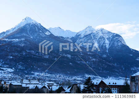 Cityscape of Brianson, ski resort in France. Mountain covered with snow and fog. Alpine landscape Cityscape of Brianson, ski resort in France. Mountain covered with snow and fog. Alpine landscape 111363985