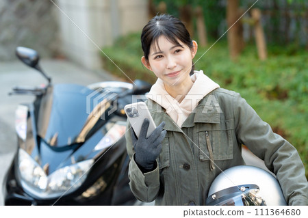 Biker girl with smartphone Biker girl with smartphone 111364680