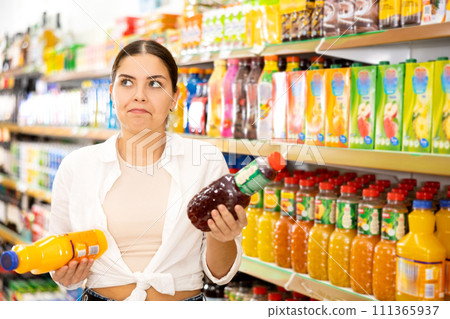 in shop, smiling girl chooses drink. 111365937