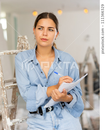 Female architect matching check list during repair works 111366329