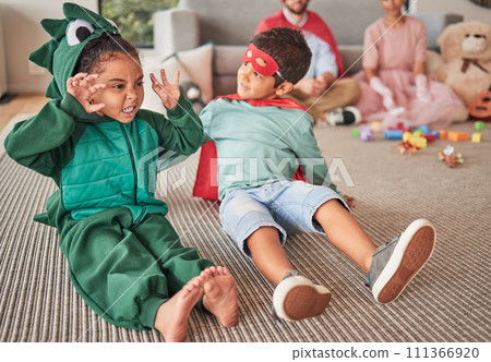 Family, halloween and children playing in costume on a floor in a living room, having fun and being creative. Superhero, dinosaur and creative kids bonding in character, excited and happy together Family, halloween and children playing in costume on a floor in a living room, having fun and being creative. Superhero, dinosaur and creative kids bonding in character, excited and happy together 111366920