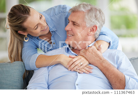 Happy senior dad with adult daughter on couch in home, quality time together in retirement with quality loving time. Young woman shows healthy, smiling father love and relaxing in living room 111367463