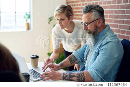 business people using laptop computer working in office team leader woman sharing ideas with male colleague looking at screen 111367484