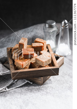 Brown sugar in wooden box on slate background 111367774
