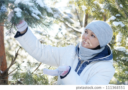 Happy young woman posing in snowy winter park 111368551