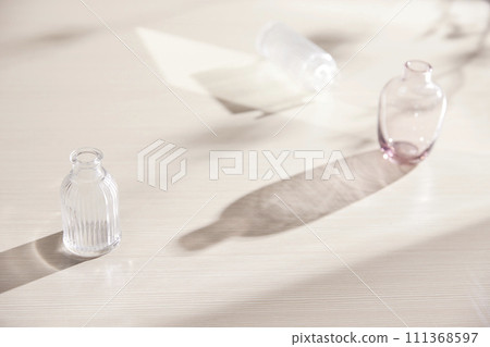 Natural texture of various glass cups on a table with sunlight streaming in. Natural texture of various glass cups on a table with sunlight streaming in. 111368597